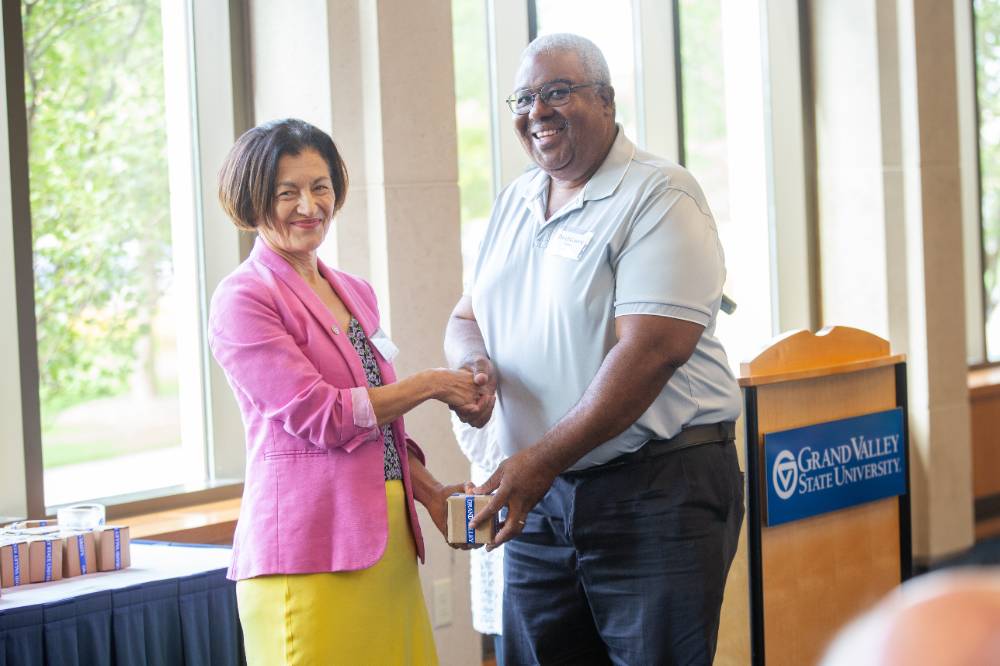 Provost Mili shaking a retiree's hand.